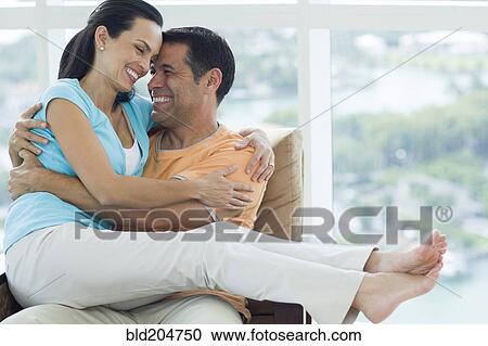 Hispanic couple hugging in armchair View Large Photo Image Stock Image - Hispanic couple hugging in armchair. Fotosearch