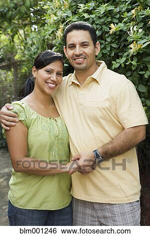 Stock Photograph - Hispanic couple hugging outdoors. Fotosearch