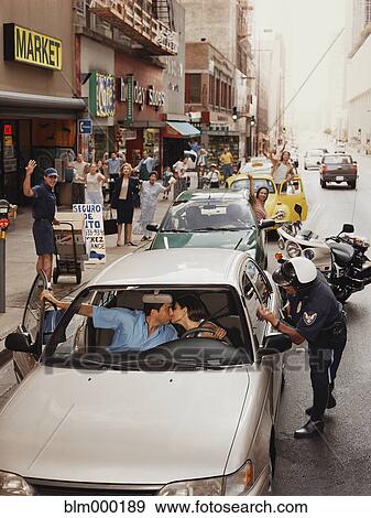 Stock Photo - Hispanic couple kissing in car and holding up traffic. Fotosearch