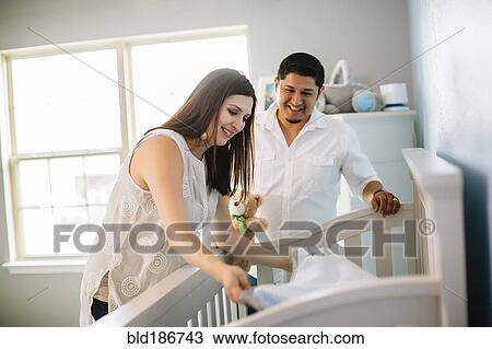 Hispanic couple preparing crib bed in nursery View Large Photo Image Stock Image - Hispanic couple preparing crib bed in nursery. Fotosearch