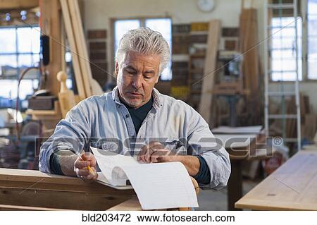 Stock Image - Hispanic craftsman working in studio. Fotosearch