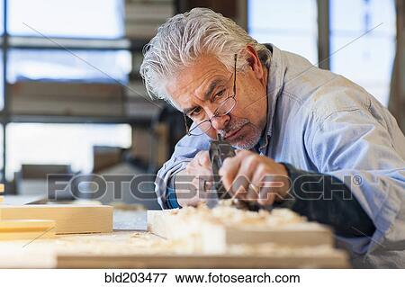 Stock Photo - Hispanic craftsman working in studio. Fotosearch