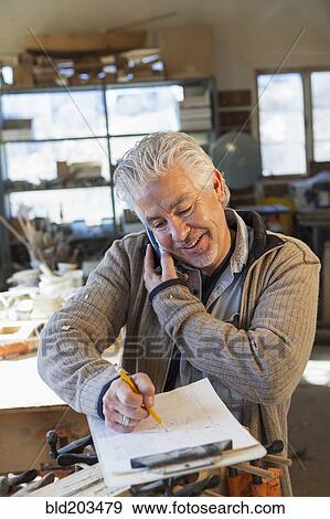 Stock Photo - Hispanic craftsman working in studio. Fotosearch