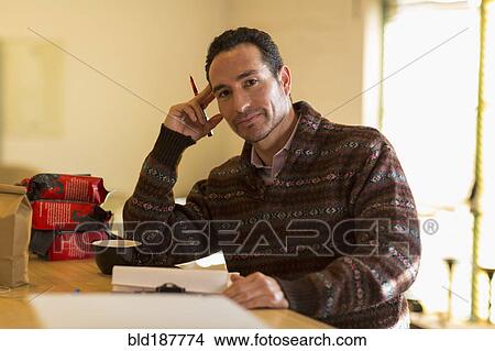 Picture - Hispanic entrepreneur taking inventory in store. Fotosearch