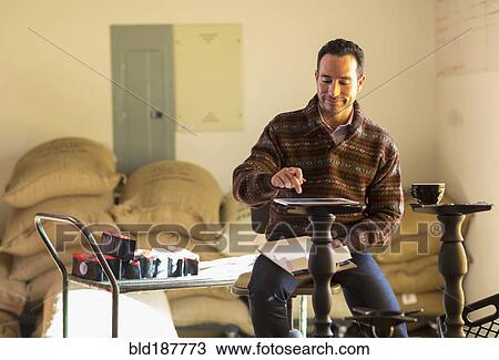 Stock Image - Hispanic entrepreneur using digital tablet. Fotosearch
