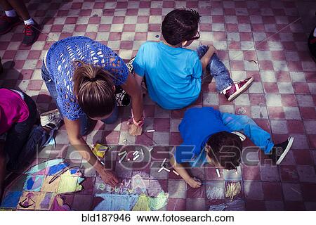 Stock Photograph - Hispanic family drawing with chalk on floor. Fotosearch