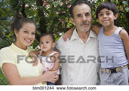 Picture - Hispanic family posing near fence. Fotosearch