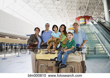 Hispanic family posing with luggage in airport View Large Photo Image Stock Image - Hispanic family posing with luggage in airport. Fotosearch