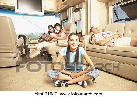 Stock Image - Hispanic family relaxing in recreational vehicle. Fotosearch