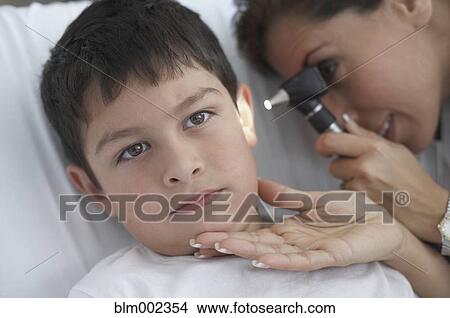 Picture - Hispanic female doctor examining patient. Fotosearch
