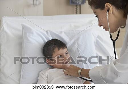 Stock Image - Hispanic female doctor examining patient. Fotosearch