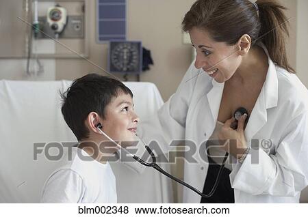 Stock Photo - Hispanic female doctor letting boy use stethoscope. Fotosearch