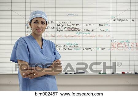 Stock Photo - Hispanic female medical professional in front of schedule board. Fotosearch
