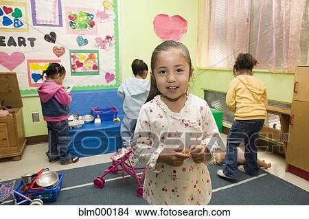 Picture - Hispanic girl in classroom play area. Fotosearch