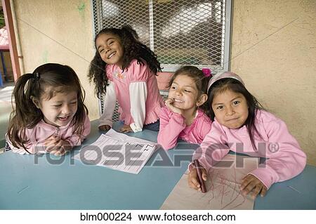 Picture - Hispanic girls coloring at table. Fotosearch