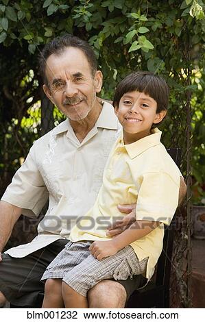 Stock Image - Hispanic grandfather hugging grandson. Fotosearch