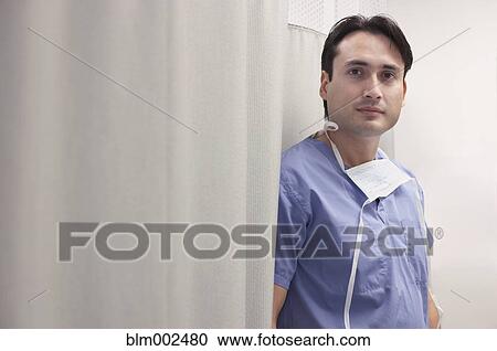 Stock Image - Hispanic male doctor next to curtain. Fotosearch