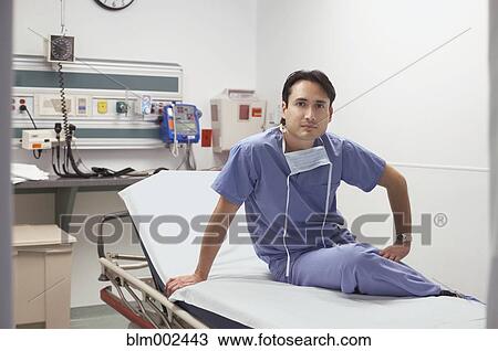 Hispanic male doctor sitting on hospital bed View Large Photo Image Stock Image - Hispanic male doctor sitting on hospital bed. Fotosearch
