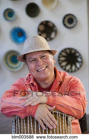 Hispanic man leaning on drum View Large Photo Image Stock Photo - Hispanic man leaning on drum. Fotosearch