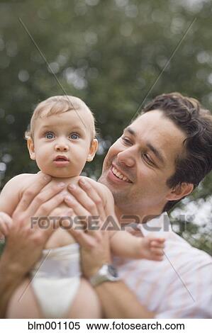 Hispanic man looking at baby View Large Photo Image Stock Photography - Hispanic man looking at baby. Fotosearch