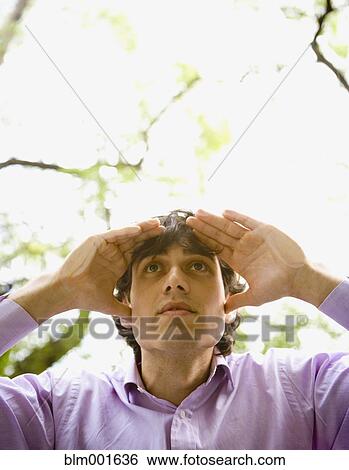 Stock Photograph - Hispanic man looking through window . Fotosearch