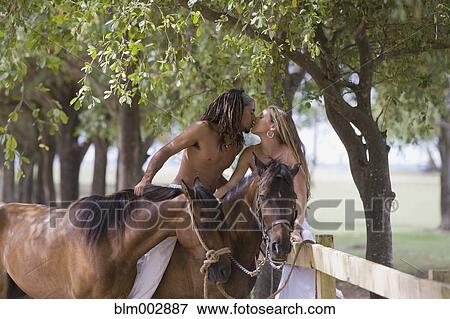 Stock Photo - Hispanic man on horseback kissing girlfriend. Fotosearch