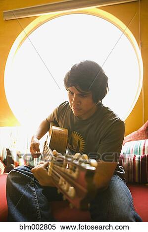 Stock Photography - Hispanic man playing guitar. Fotosearch