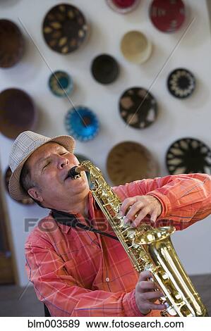 Stock Photo - Hispanic man playing saxophone. Fotosearch