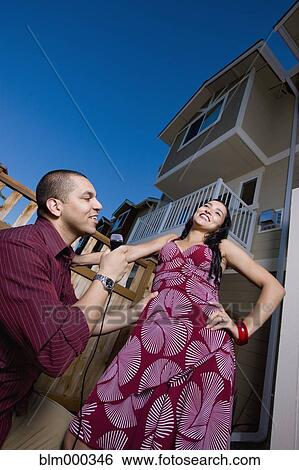 Hispanic man singing to girlfriend in backyard View Large Photo Image Stock Photograph - Hispanic man singing to girlfriend in backyard. Fotosearch