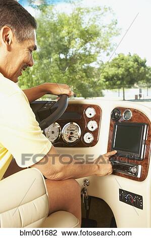 Stock Image - Hispanic man using GPS in recreational vehicle . Fotosearch