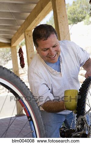 Hispanic man washing bicycle View Large Photo Image Stock Photo - Hispanic man washing bicycle. Fotosearch