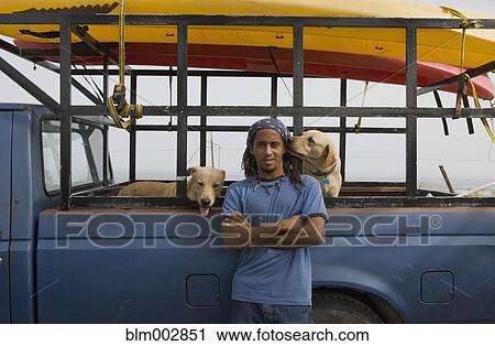 Hispanic man with dogs leaning against truck View Large Photo Image Stock Image - Hispanic man with dogs leaning against truck. Fotosearch