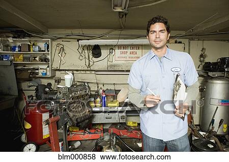 Stock Photo - Hispanic mechanic in garage. Fotosearch