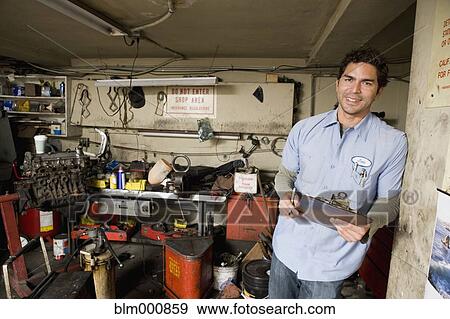 Stock Photo - Hispanic mechanic in garage. Fotosearch