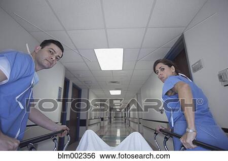 Stock Photograph - Hispanic medical professionals pushing gurney. Fotosearch