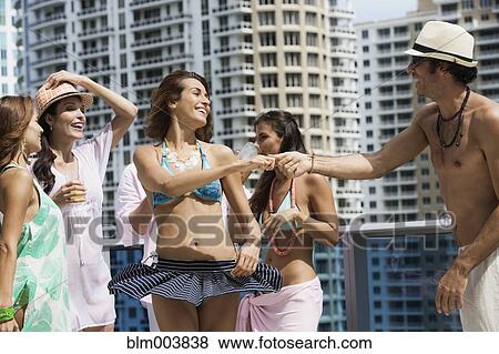 Stock Photo - Hispanic men and women dancing on rooftop. Fotosearch