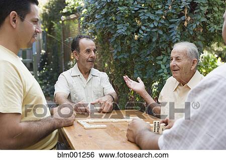 Hispanic men playing dominos on patio View Large Photo Image Stock Photograph - Hispanic men playing dominos on patio. Fotosearch