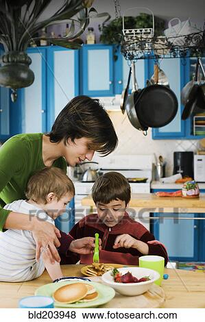 Hispanic mother and children having breakfast View Large Photo Image Stock Photo - Hispanic mother and children having breakfast. Fotosearch