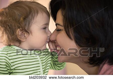Stock Image - Hispanic mother and toddler touching noses. Fotosearch