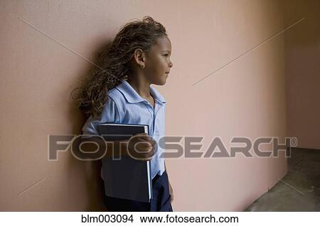 Picture - Hispanic school girl holding textbook. Fotosearch