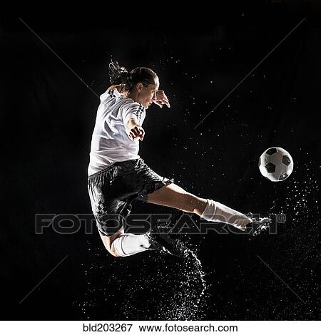Stock Photo - Hispanic soccer player splashing in water. Fotosearch
