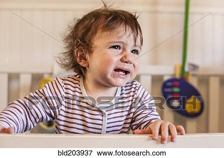 Stock Photo - Hispanic toddler crying in crib. Fotosearch