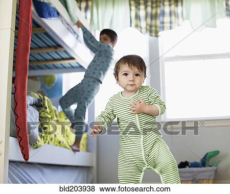 Stock Photo - Hispanic toddler standing in bedroom. Fotosearch