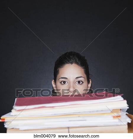 Hispanic woman behind tall stack of paperwork View Large Photo Image Stock Photo - Hispanic woman behind tall stack of paperwork. Fotosearch