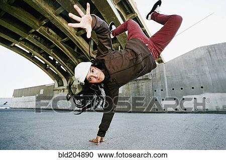 Hispanic woman break dancing under overpass View Large Photo Image Stock Image - Hispanic woman break dancing under overpass. Fotosearch