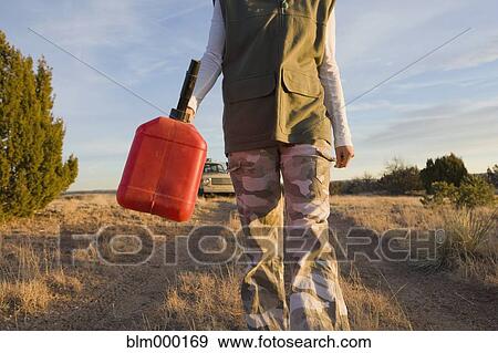 Stock Photo - Hispanic woman carrying gas can. Fotosearch