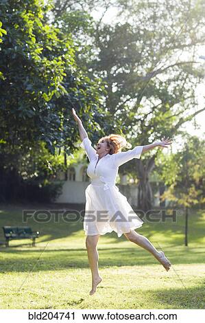 Stock Image - Hispanic woman dancing outdoors. Fotosearch