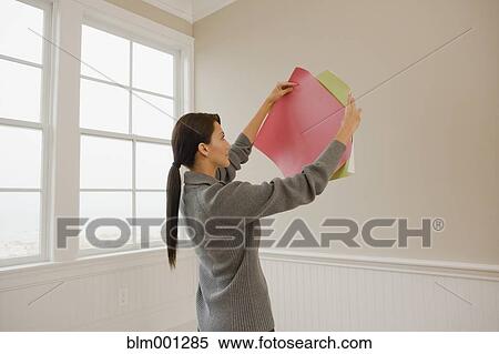 Stock Photography - Hispanic woman holding color swatches. Fotosearch