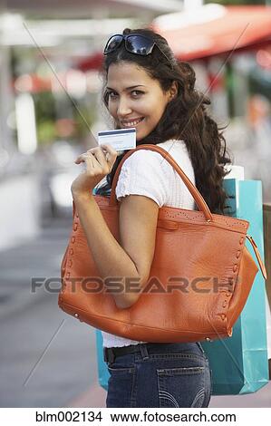 Picture - Hispanic woman holding credit card. Fotosearch