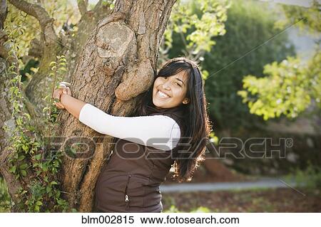 Hispanic woman hugging tree View Large Photo Image Stock Photography - Hispanic woman hugging tree. Fotosearch